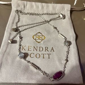 Long silver necklace with a dark purple stone and two small silver stones